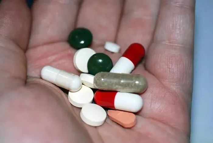 Горсть таблеток в руке